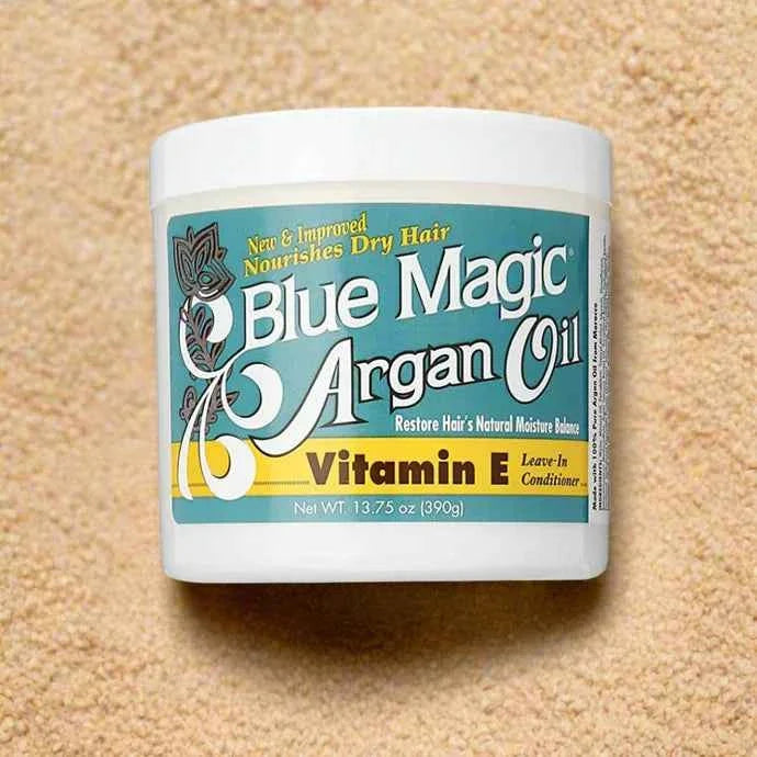 Blue Magic Argan Oil Vitamin E leave-in conditioner in a 13.75oz bottle, showcasing the product with a sleek blue design and applicator.