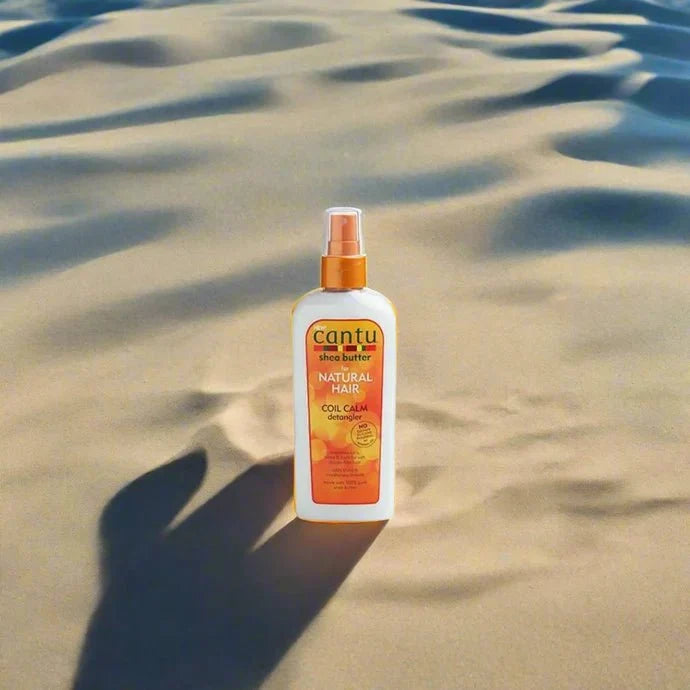 Cantu Shea Butter Coil Calm Detangler 8oz bottle with a pump dispenser, featuring a white and blue label and clear product view.