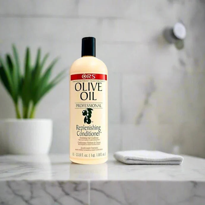 ORS Olive Oil Replenishing Conditioner in a large 33.8 fl oz bottle, with a white and green label and pump dispenser.